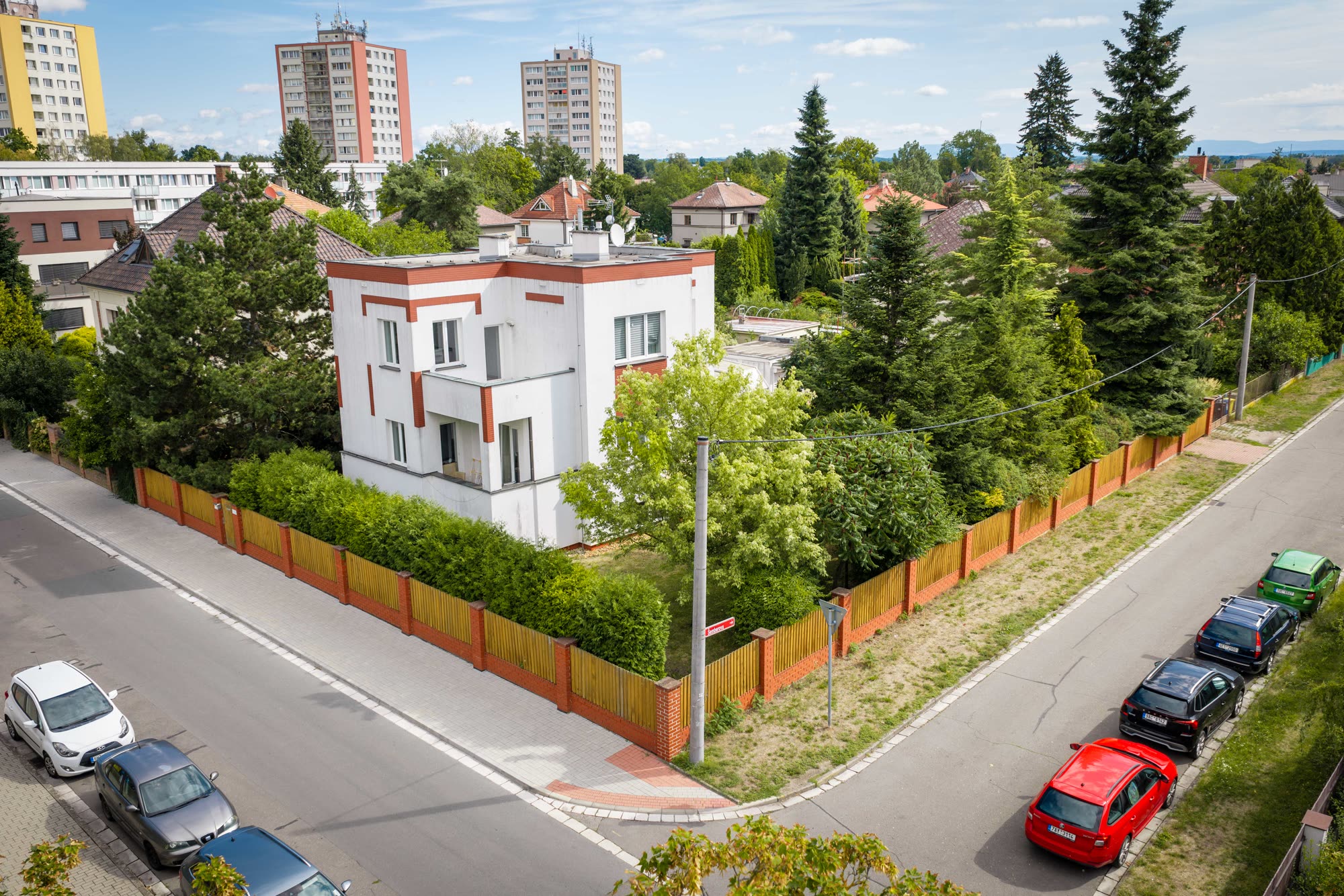 Dronový snímek – dům v kontextu okolní rodinné i bytové zástavby.